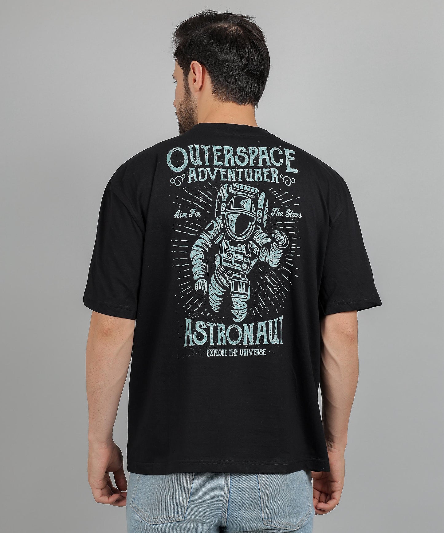 Model wearing men’s black oversized t‑shirt with graphic print and drop-shoulder style