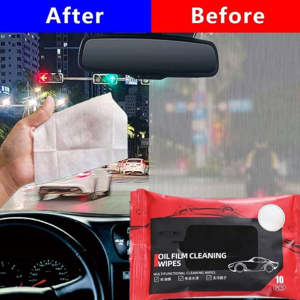 Hand holding oil film removal wipe over clear car window
